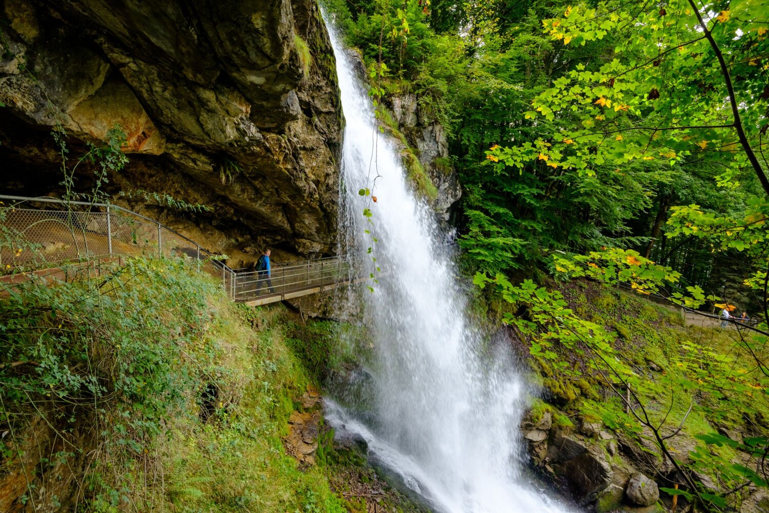 Hinter einer der 14 Kaskaden des Giessbachfalls führt der Wanderweg hindurch.