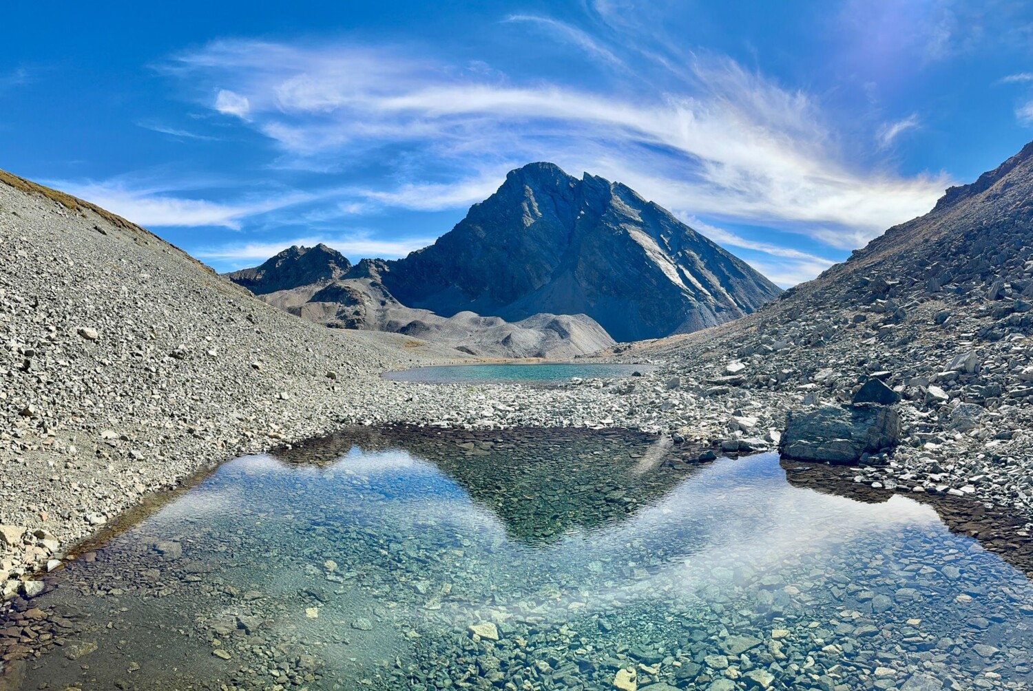 Der Piz Linard spiegelt sich in einem kleinen See auf dem Vereinapass.