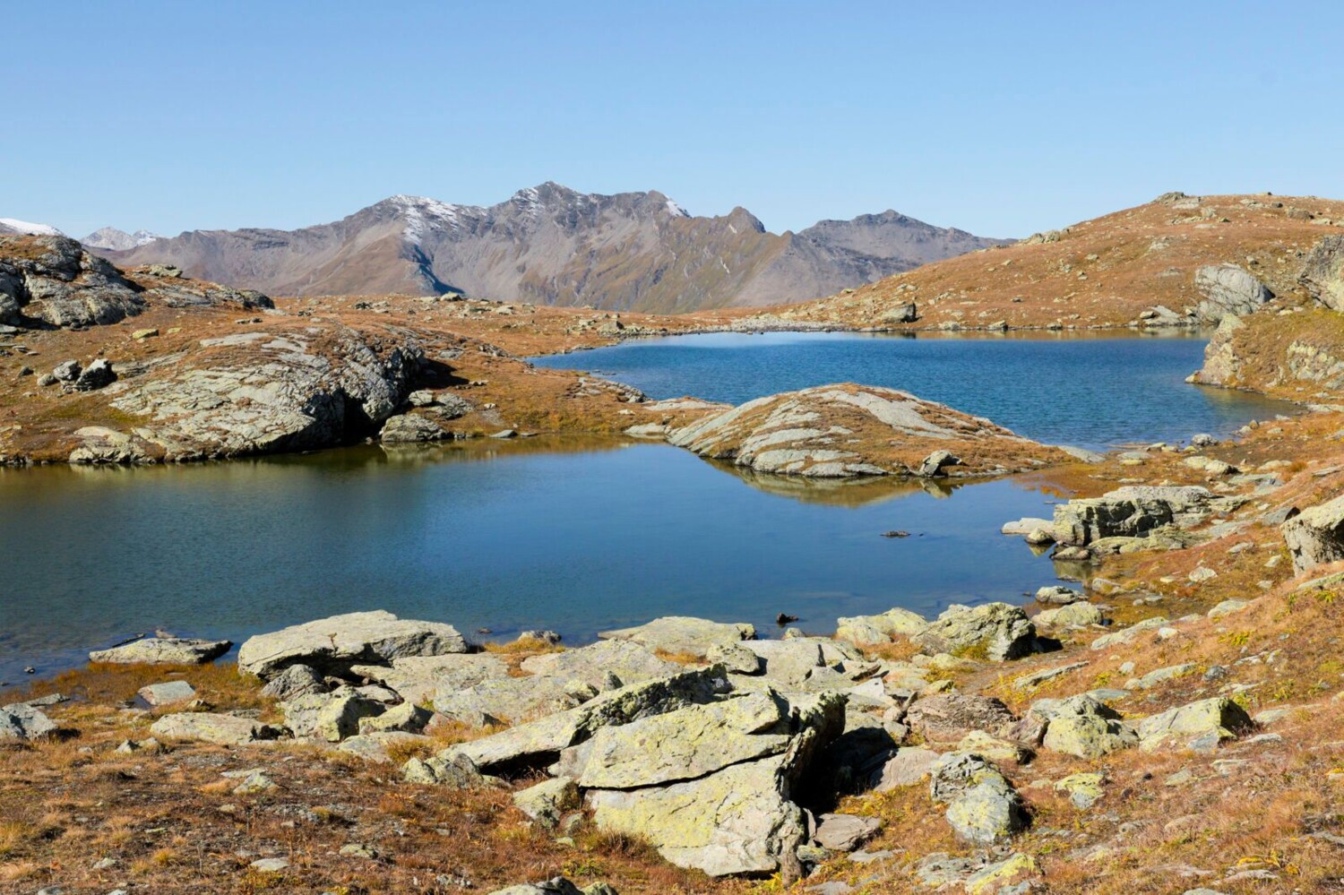 Die Flüeseen liegen nur ein paar Minuten vom Weg entfernt und bieten sich für eine perfekte Pause an. Hinten die Tscheischhorn-Kette.