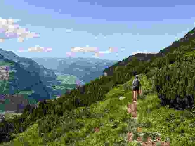 Des pins de montagne bordent le chemin. Dans la vallée, Innertkirchen est déjà visible.