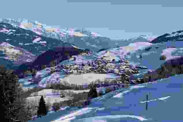 Ein kurzer Blick zurück auf Meierhof, wo die Winterwanderung gestartet ist. Im Hintergrund die Berge der Surselva.